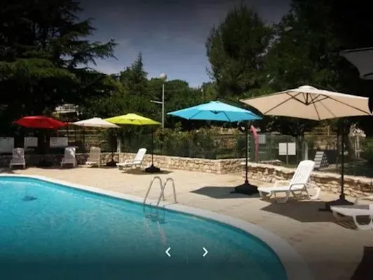 Zona de piscina con sombra y sombrillas